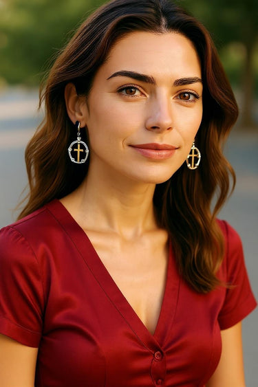 Woman wearing gold earrings with a blurred outdoor background